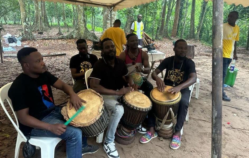 Des jeunes jouent du tambour en forêt